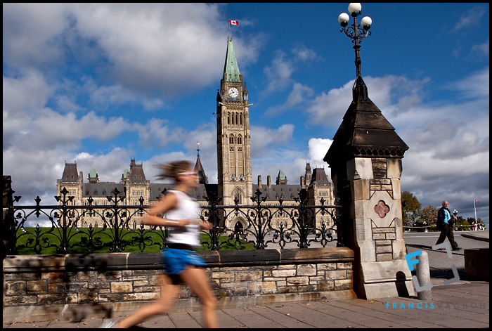 A woman runs by the Parliament in Ottawa Monday September 27, 2010. Parliament Hill (colloquially The Hill, in French: Colline du Parlement) is an area of Crown land on the southern banks of the Ottawa River in downtown with a Gothic revival suite of buildings, the parliament buildings, that serves as the home of the Parliament of Canada and contains a number of architectural elements of national symbolic importance.